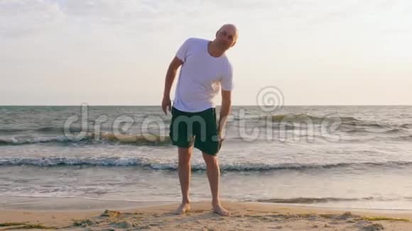 中年人在海边美丽的沙滩上打电话视频的预览图