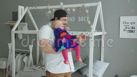 快乐的爸爸带着笑的宝宝看窗外视频的预览图
