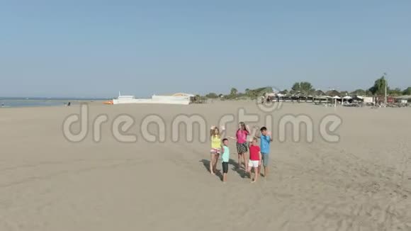 儿童在海滩上挥舞双手的空中射击视频的预览图