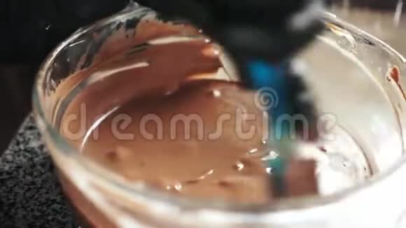 用铲子在玻璃碗里搅拌融化的巧克力视频的预览图