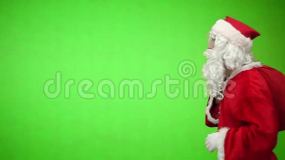 圣诞快乐穿着红色西装的圣诞老人拿着一个带礼物的袋子挥动着他的手进入框架并从中取出视频的预览图