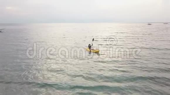 空中景色夏天一位年轻的女性独自在宁静的热带海洋中皮划艇视频的预览图