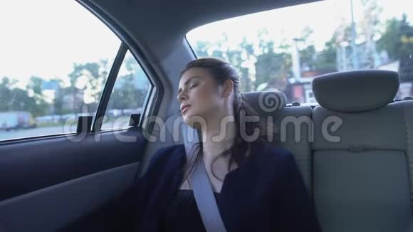 昏昏欲睡的女人在出租车里醒来环顾四周工作累坏了精疲力竭视频的预览图
