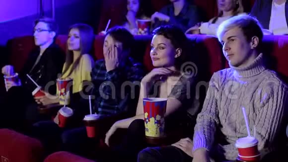 年轻有趣的青少年在电影院看有趣的电影他们吃爆米花视频的预览图