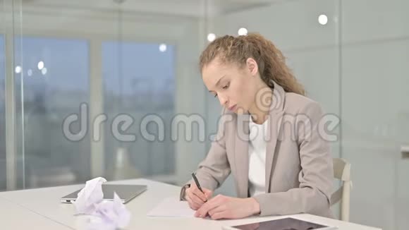 年轻女商人试图在办公室写文件视频的预览图
