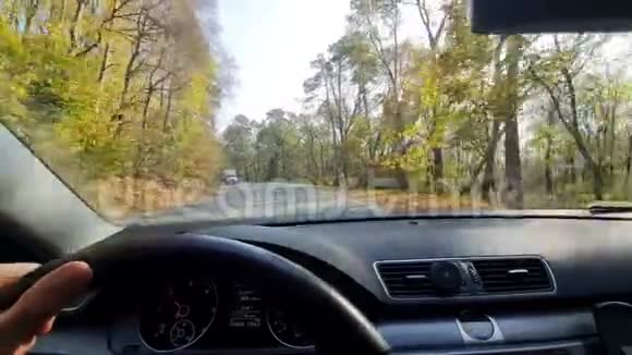 男性手放在汽车的方向盘上看着司机眼睛看着路乘坐汽车在两者之间的高速公路上旅行视频的预览图