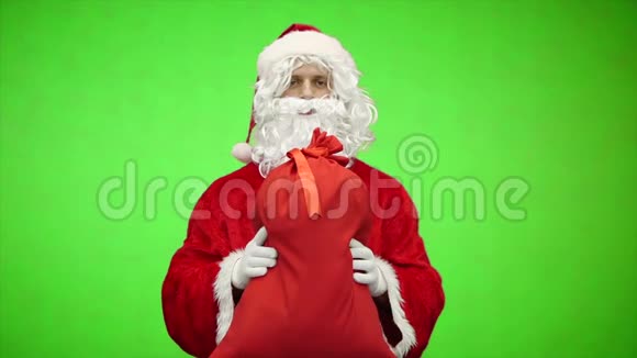 圣诞老人的肖像在绿色背景上赠送带有礼物的袋子慢动作视频的预览图