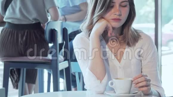 伤心的女人独自坐在咖啡店里视频的预览图