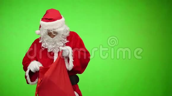 圣诞老人从绿色背景的袋子里得到礼物视频的预览图