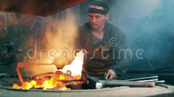 男铁匠用金属扑克运煤车间铁匠锻铁视频的预览图