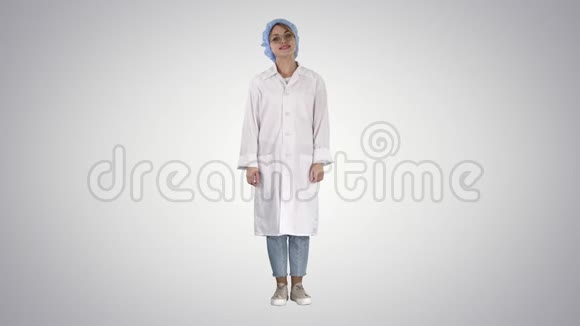 女医生双手放在臀部站立放松和微笑非常积极和开朗的梯度背景视频的预览图