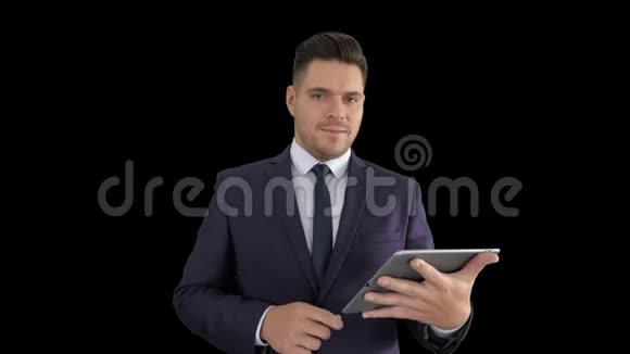 帅哥在平板电脑上翻页对着镜头微笑阿尔法频道视频的预览图