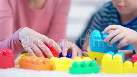 女儿童心理学家和小男孩在测试过程中玩彩色立方体的特写视频的预览图