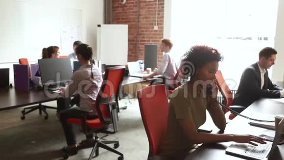跨国公司雇员坐在现代化的合用办公室视频的预览图
