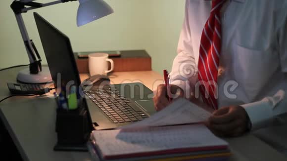 穿西装的人在办公室里用笔记本电脑工作穿白衬衫戴红领带的商人视频的预览图