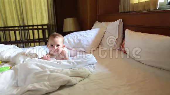 婴儿在尿布上滑稽地爬在床上视频的预览图