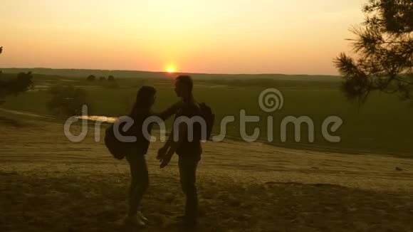 旅者一男一女舞欢快男人在夕阳下把他心爱的女人抱在怀里团队合作视频的预览图