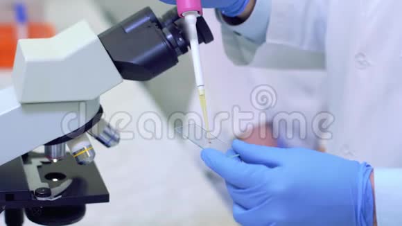 科学家在医学实验室通过显微镜进行科学研究液体滴在地上视频的预览图