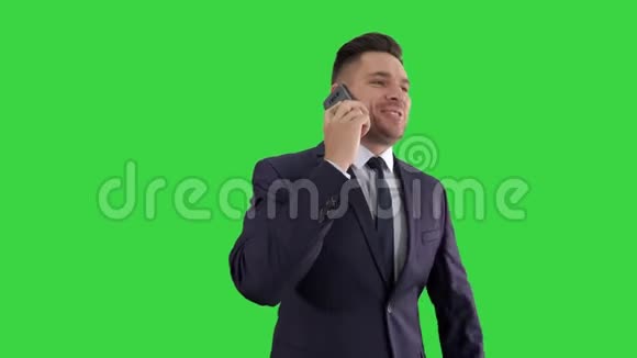 商人在绿色屏幕上愉快地用手机交谈Chroma键视频的预览图