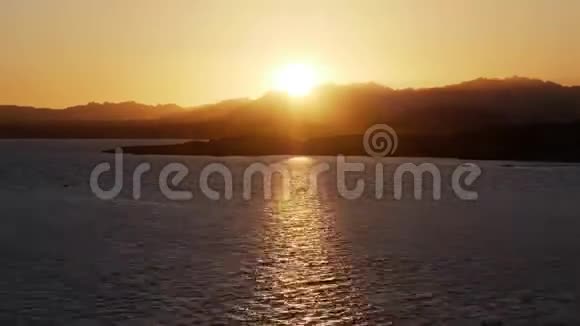 海上浪漫日落的时间流逝日落时太阳随着群山从地平线上下山岛屿上的日落视频的预览图