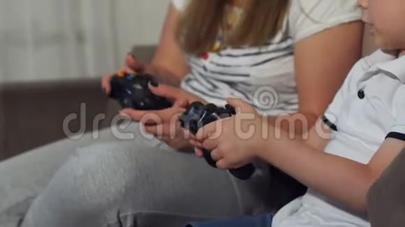 特写一个女孩和一个孩子玩电子游戏手里拿着操纵杆视频的预览图