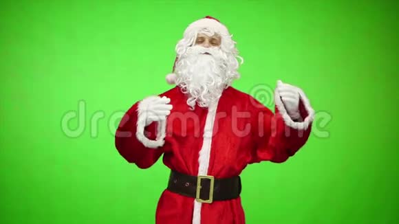 传统的圣诞老人站在绿色的背景上他的腰带慢动作视频的预览图