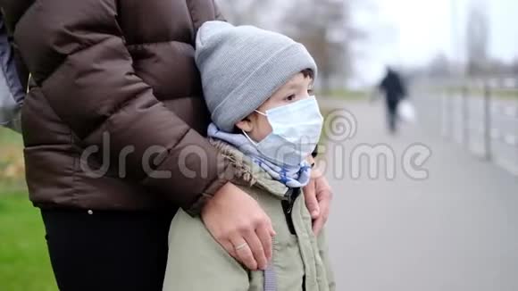 秋天一位戴着医用口罩的年轻女子站在一座城市的街道上视频的预览图