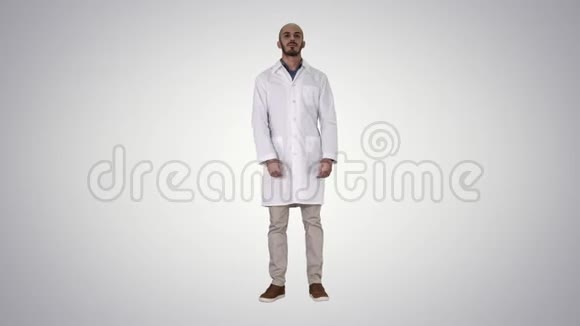 站在渐变背景下的年轻严肃的阿拉伯医生视频的预览图