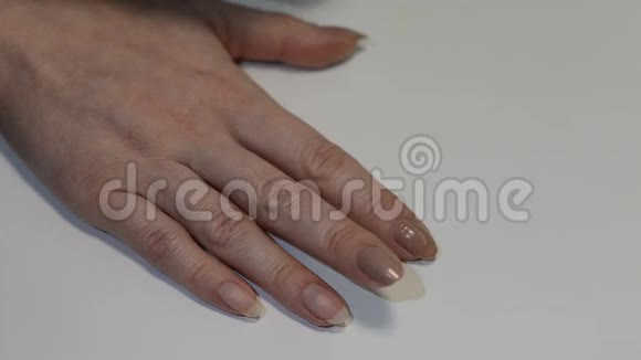 女人用棉垫去除旧指甲油做手指甲视频的预览图