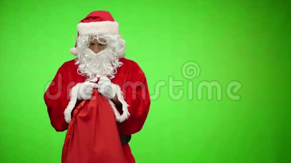 圣诞老人带着礼物看着袋子摸了摸头色度键慢动作视频的预览图
