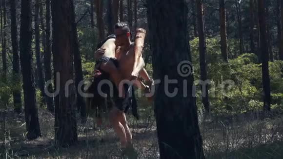肌肉男在森林里散步肩膀上有一个女人视频的预览图