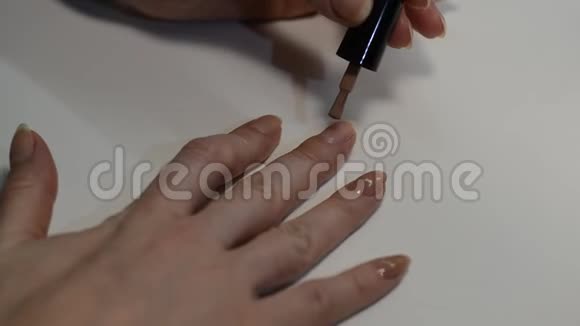 女人在修指甲时用米色指甲油涂指甲视频的预览图