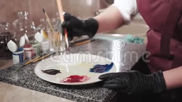 将不同颜色的食用染料与盘子上的刷子混合视频的预览图