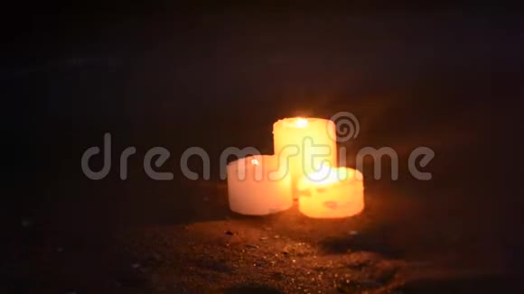 海边沙滩上有三支小蜡烛海浪在燃烧视频的预览图