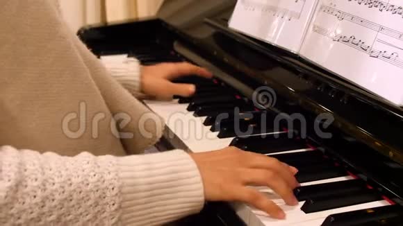 女子阅读笔记和快速旋律的钢琴手特写4k视频的预览图