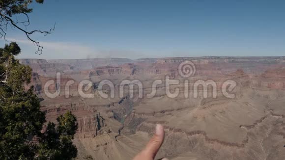 游客展示大峡谷的大拇指背景视频的预览图