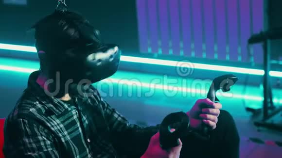 大胡子男子玩虚拟现实游戏使用现代虚拟现实耳机与游戏垫遥控器视频的预览图