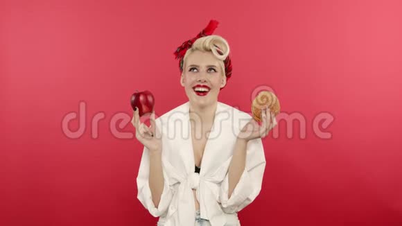 微笑着钉住女人拿着苹果和汉堡包视频的预览图