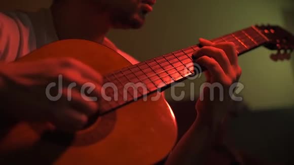吉他音乐家排练他在一个灯光昏暗的房间里视频的预览图