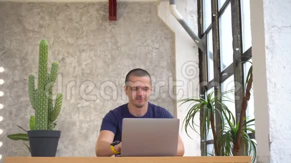 一个人在笔记本电脑上工作然后对着镜头竖起大拇指微笑着视频的预览图