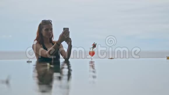 快乐的美国女人自拍照片是在池边的蓝色背景视频的预览图