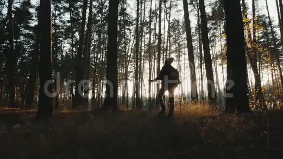 一个带着跋涉杆的女孩站在森林的中央视频的预览图