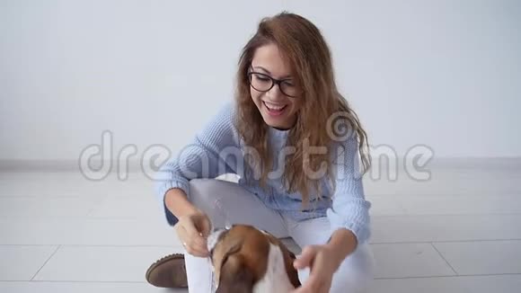 爱动物的概念快乐的年轻女人在家玩她可爱的小狗视频的预览图