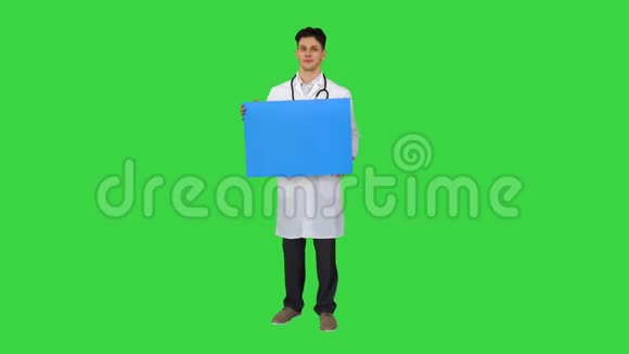 微笑男医生穿着听诊器拿着绿色屏幕上的空白海报色度键视频的预览图