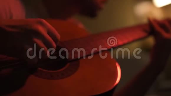 吉他音乐家排练他在一个灯光昏暗的房间里视频的预览图