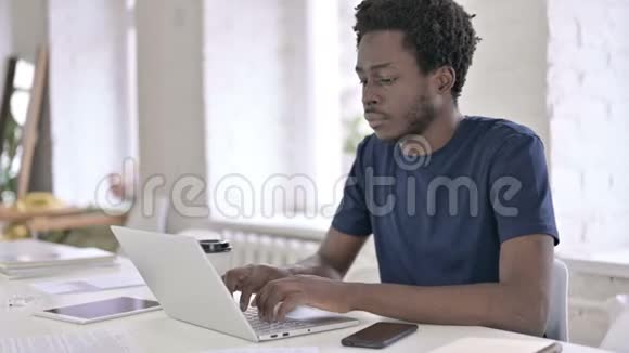 疲惫的非洲年轻人在办公室里背痛视频的预览图