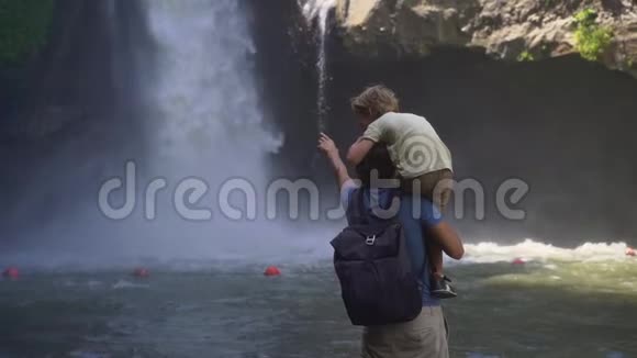 在巴厘岛乌布达岛上参观特根甘瀑布的父子慢镜头视频的预览图