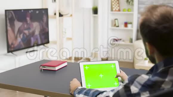 男人用绿色屏幕在数码平板电脑上滚动视频的预览图
