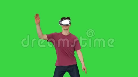 休闲男子在VR眼镜跳舞玩电子游戏初学者水平的绿色屏幕铬键视频的预览图