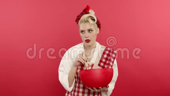 在粉色背景下做饭的女孩视频的预览图